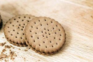 Crispy chocolate cinnamon with holes on a wooden board. Round biscuits with filling. space for text photo