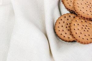 Crispy chocolate cinnamon with holes on a wooden board. Round biscuits with filling. space for text photo