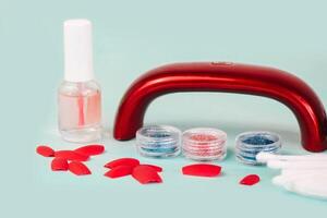 manicure flat on a turquoise background. glitters for manicure or makeup design, false nails photo
