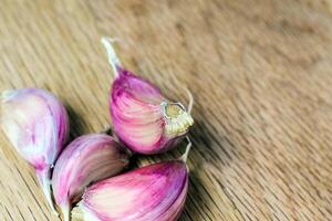 cloves of garlic on a wooden background close-up. Purple garlic photo
