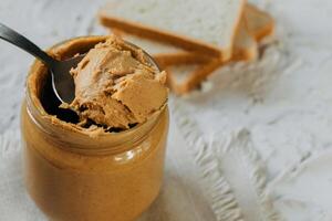 thick peanut butter in a jar close-up. Healthy eating photo