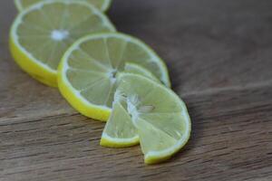lemon slices neatly cut and lie on a wooden background. space for text photo