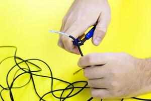 man snacks a cable nippers on a yellow background photo