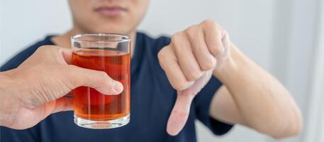 man refuses say no and avoid to drink an alcohol whiskey , stopping hand sign male, alcoholism treatment, alcohol addiction, quit booze, Stop Drinking Alcohol. Refuse Glass liquor, unhealthy, reject photo