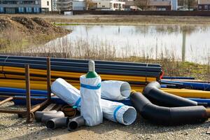 Construction site with pipes of different colors and sizes located on it. photo