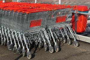 Shopping carts with red handles near a supermarket. photo