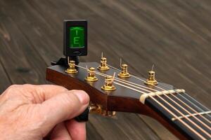 Close-up of a guitar neck while tuning. photo