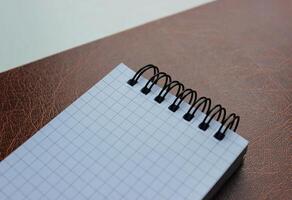 Beginnings And Ideas Concept. Leather Paper Folder With Clean Checkered Binder Notepad photo