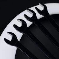 Arranged By Numbers Four Spanners Over Curved Lamp Closeup Square Stock Photo