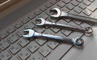 Computer Service Illustration Stock Image. Hand Wrenches On Computer Keyboard With Latin And Cyrillic Letters photo