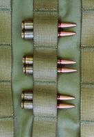 Combat cartridges are attached to tactical belts vertical stock photo for military backgrounds