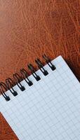 Spiral Pad With Clean Page On Brown Leather Concept Photo For Vertical Backgrounds