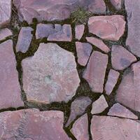Red granite stones placed in an old masonry texture background. Square stone background stock photo