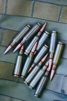 Heap Of Live Ammunition On Tactical Military Fabric With Threaded Belts photo