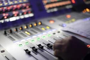 The sound engineer's hands move the sliders of the device. photo