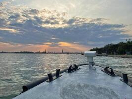 A view of Venice from a boat on the sunset photo