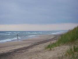 Scenic view of the sea and sand dune on the beach on a gloomy, cloudy weather, Skagen, Denmark photo