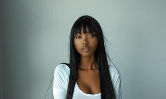 Portrait of a Beautiful African American Woman with Long Straight Black Hair and Confident Expression in Minimalist Setting photo