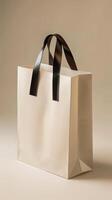 Classic Minimalistic Design of a Paper Bag with Black Handles Against a Soft Beige Background, Perfect for Elegant Retail and Eco-Friendly Branding photo