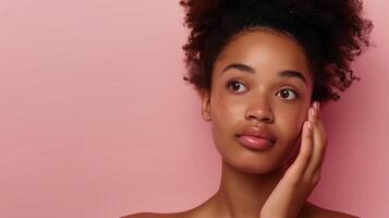 Beautiful African American Woman Demonstrating Skincare Routine Against Soft Pink Background photo