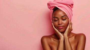 Serene African American Woman Embracing Natural Beauty with a Towel on Her Head and Relaxed Expression Against a Soft Pink Background photo