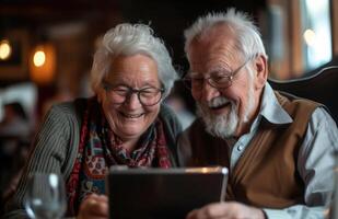 Happy Elderly Couple Laughing Together While Using a Tablet in a Cozy Setting photo