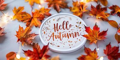 Hello Autumn Sign Surrounded by Colorful Autumn Leaves and Fairy Lights photo