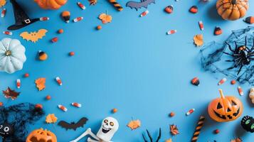 Top View of Halloween Decorations on Blue Background with Pumpkins, Bats, and Candy photo