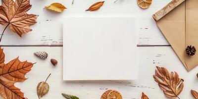 Autumn Flat Lay With Blank Card, Fall Leaves, and Envelopes on Wooden Table photo