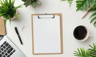 Flat Lay Of Office Desk With Clipboard, Laptop, Plants, And Coffee Cup photo