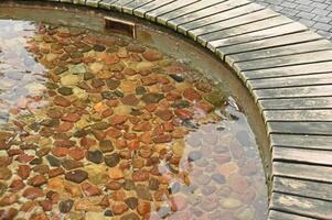 a wooden bench in the middle of a pond photo