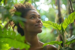 Woman traveler in the jungle in a thicket of tropical plants looking up in surprise photo