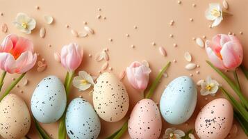 Easter pastel colored eggs with spring flowers on beige paper background, copy space, top view photo