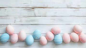 Happy Easter holiday background with colorful pastel eggs on white wooden table, top view, copy space photo