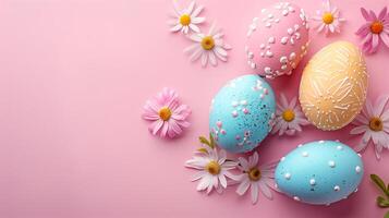 Easter pastel colored eggs with spring flowers on pink paper background, copy space, top view photo