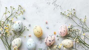 Easter colored eggs with spring flowers on pastel blue background, copy space, top view photo
