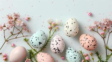 Easter colored eggs with spring flowers on pastel blue background, copy space, top view photo