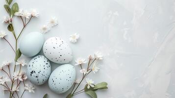 Easter colored eggs with spring flowers on pastel blue background, copy space, top view photo