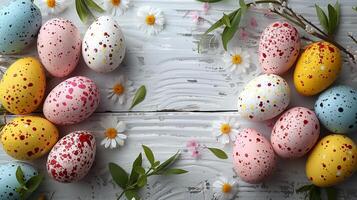 Easter pastel eggs with spring flowers on pastel wooden white background with copy space, top view photo