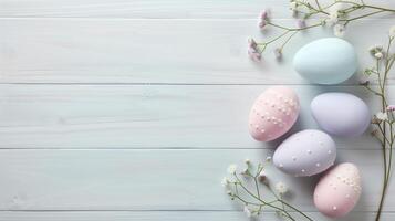 Easter pastel eggs with spring flowers on pastel wooden blue background with copy space, top view photo