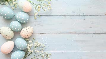 Easter pastel eggs with spring flowers on pastel wooden blue background with copy space, top view photo