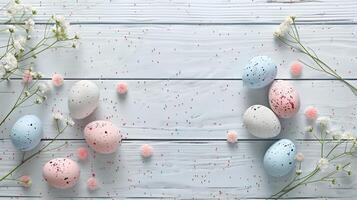 Easter pastel eggs with spring flowers on pastel wooden blue background with copy space, top view photo