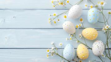 Easter pastel eggs with spring flowers on pastel wooden blue background with copy space, top view photo