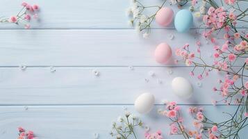Easter pastel eggs with spring flowers on pastel wooden blue background with copy space, top view photo