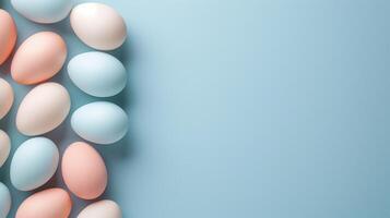 Happy Easter holiday background with colorful pastel eggs on blue paper, top view, copy space photo