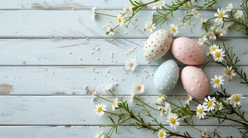 Easter pastel eggs with spring flowers on pastel wooden blue background with copy space, top view photo