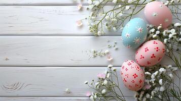 Easter pastel eggs with spring flowers on pastel wooden white background with copy space, top view photo