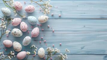 Easter pastel eggs with spring flowers on pastel wooden blue background with copy space, top view photo