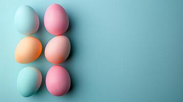 Happy Easter holiday background with colorful pastel eggs on blue paper, top view, copy space photo