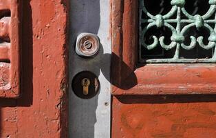 Weathered entrance with closed door, doorknob and key hole photo